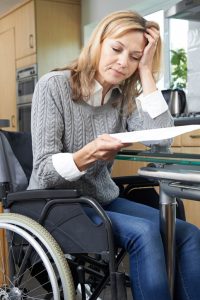 Frustrated Woman In Wheelchair Reading Letter